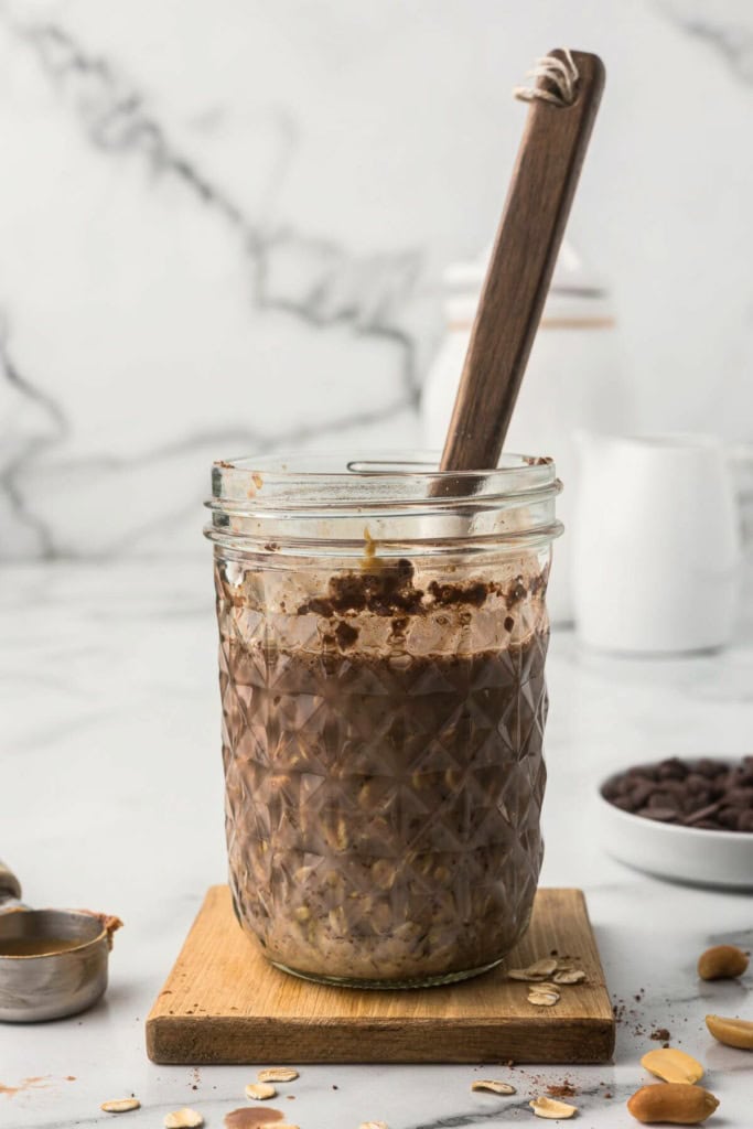 chocolate peanut butter overnight oats in a mason jar with a spoon