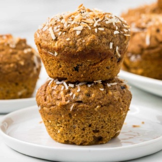 stack of two sweet potato muffins with shredded coconut on top on a white plate