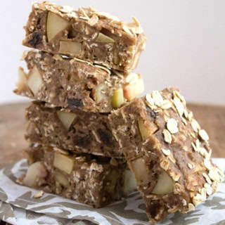 apple cinnamon oatmeal bars stacked on a paisley kitchen towel