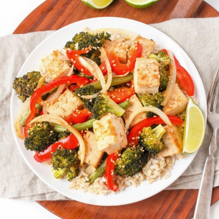 sheet pan sesame ginger tofu on a plate with rice, broccoli, and bell peppers