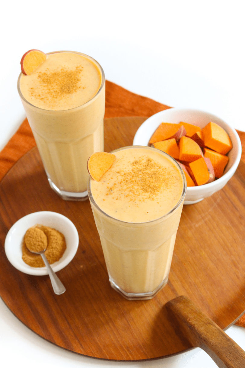 sweet potato smoothie in a tall glass topped with cinnamon