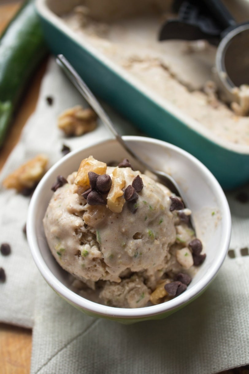 scoop of zucchini bread ice cream in a small bowl with walnuts and chocolate chips