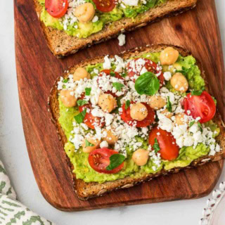 avocado feta toast with chickpeas on a wooden platter