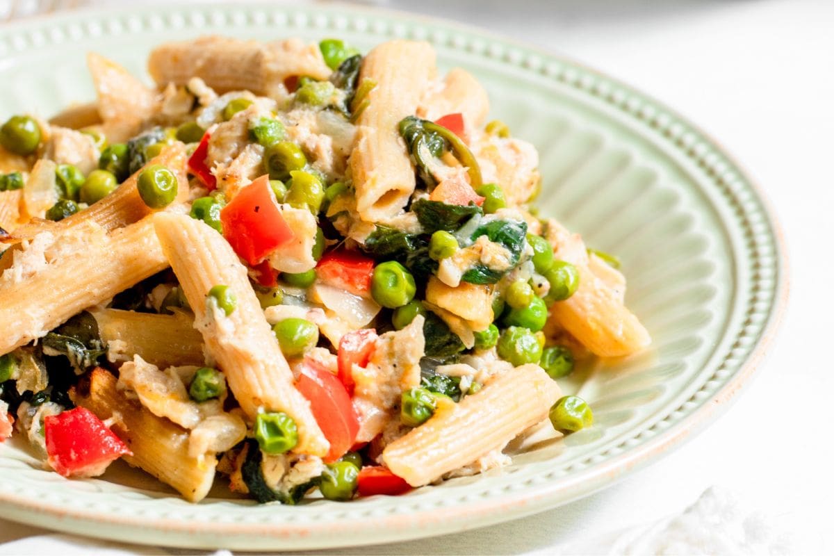 Tuna noodle casserole with vegetables in a shallow light green bowl