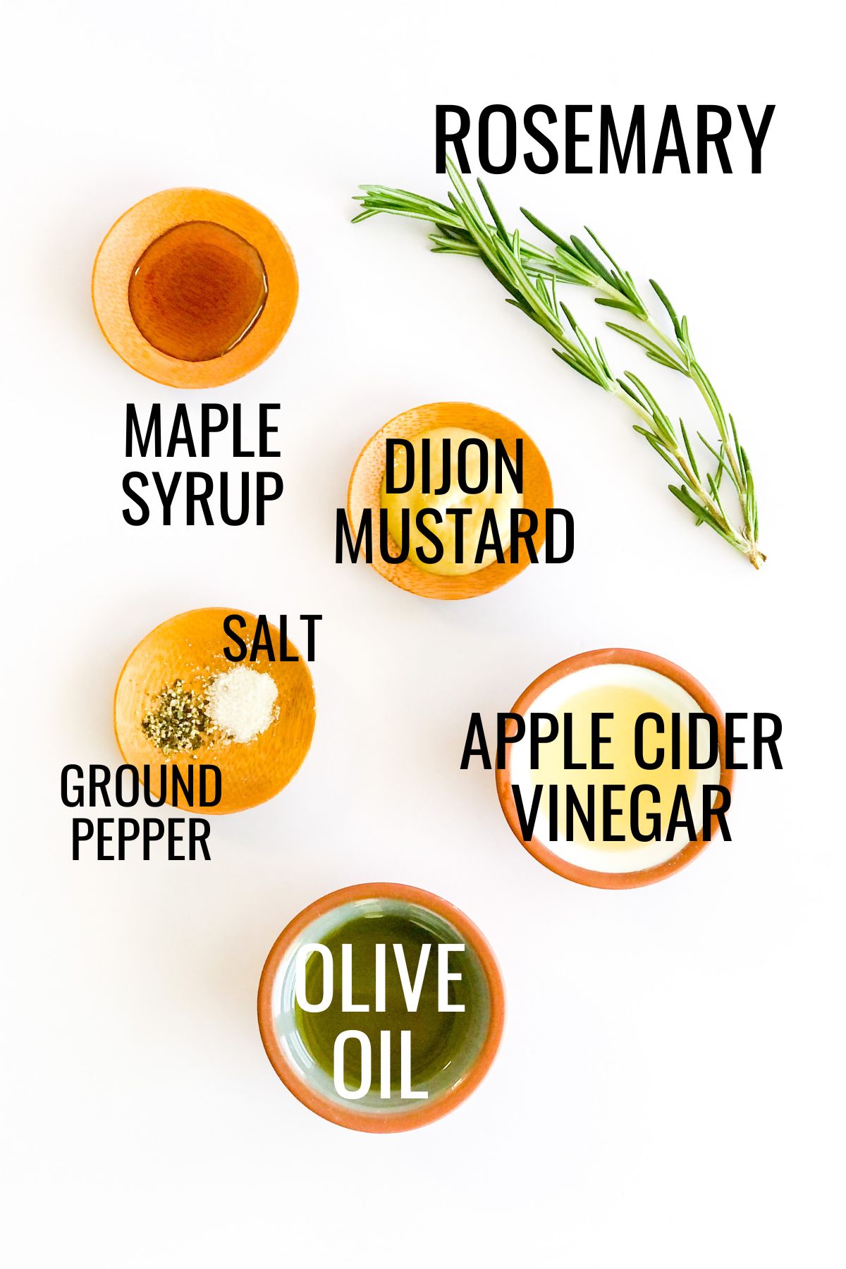 small bowls of maple syrup, dijon mustard, olive oil, and apple cider vinegar next to a sprig of fresh rosemary on a white background