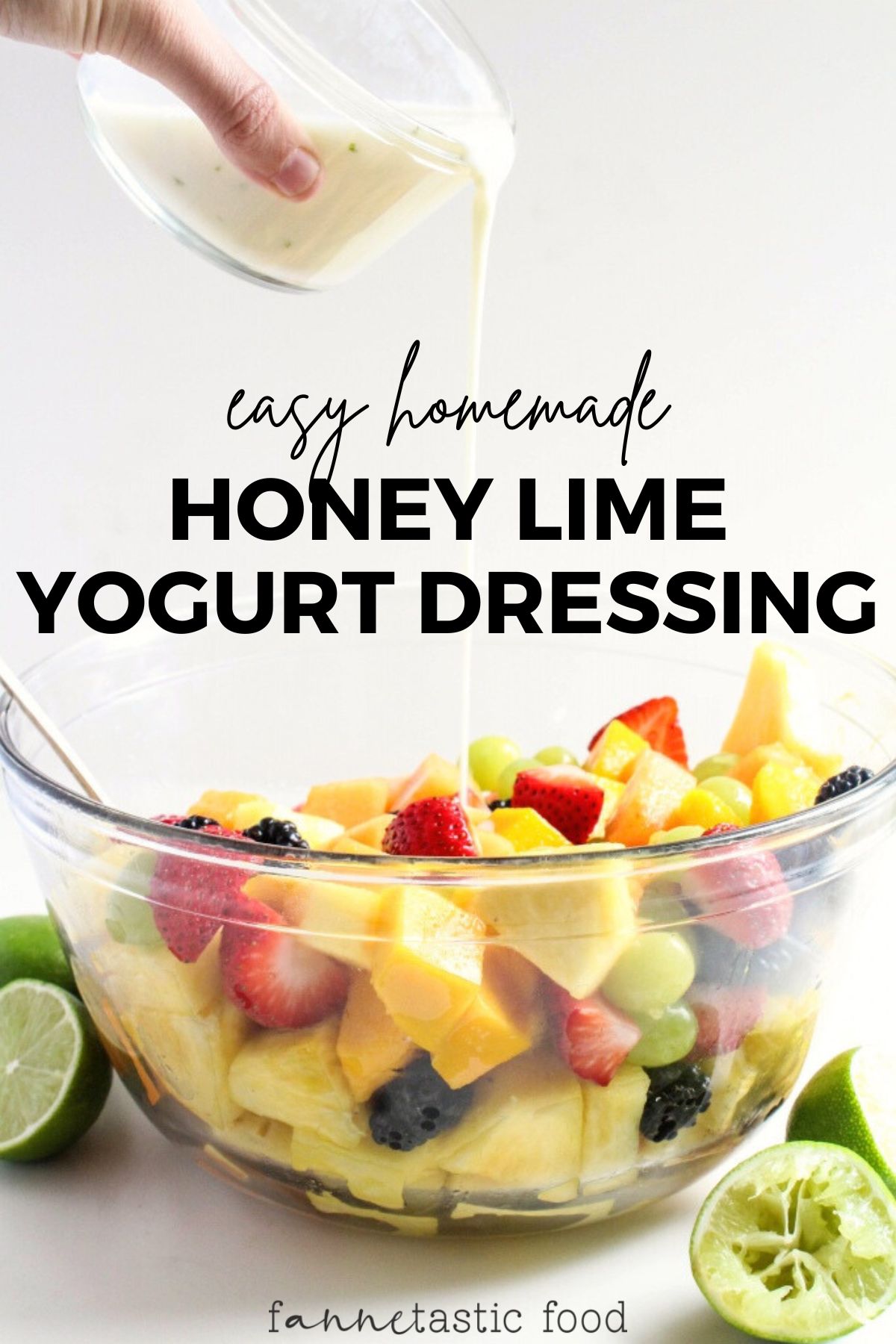 homemade lime Greek yogurt dressing with honey being poured over a glass bowl of fruit salad