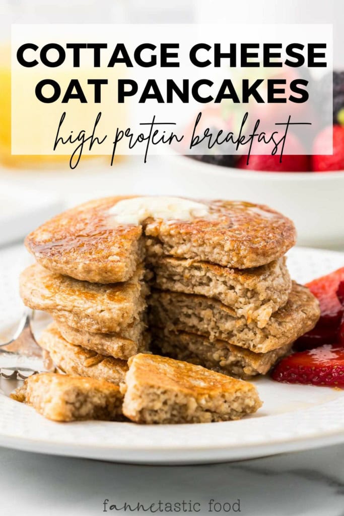 stack of cottage cheese protein pancakes with maple syrup and strawberries on a white plate