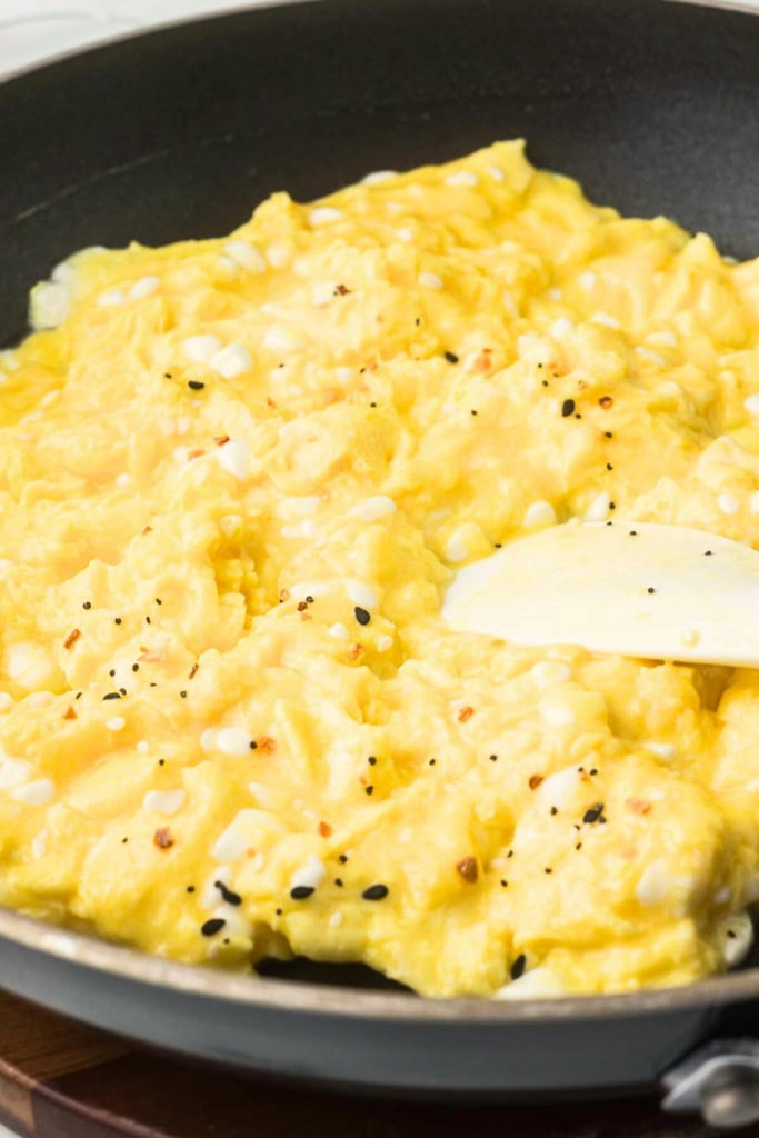 eggs being scrambled in a skillet with a spatula