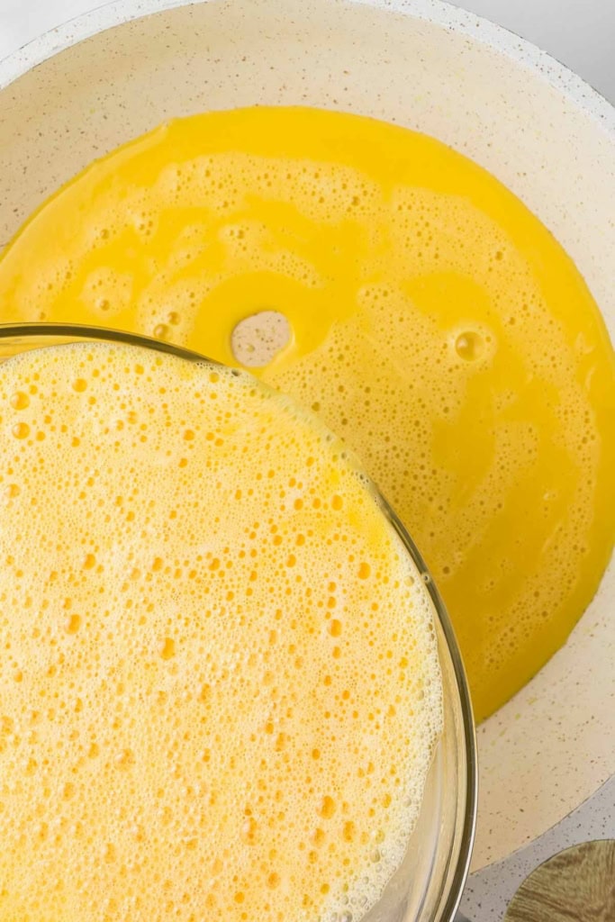 beaten eggs being poured into a skillet