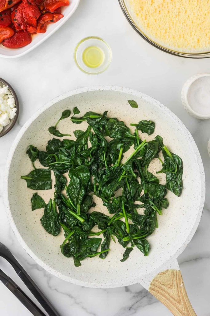 cooked spinach in a white skillet