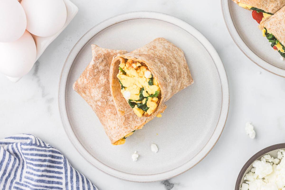 spinach feta wrap sliced in half on a white plate