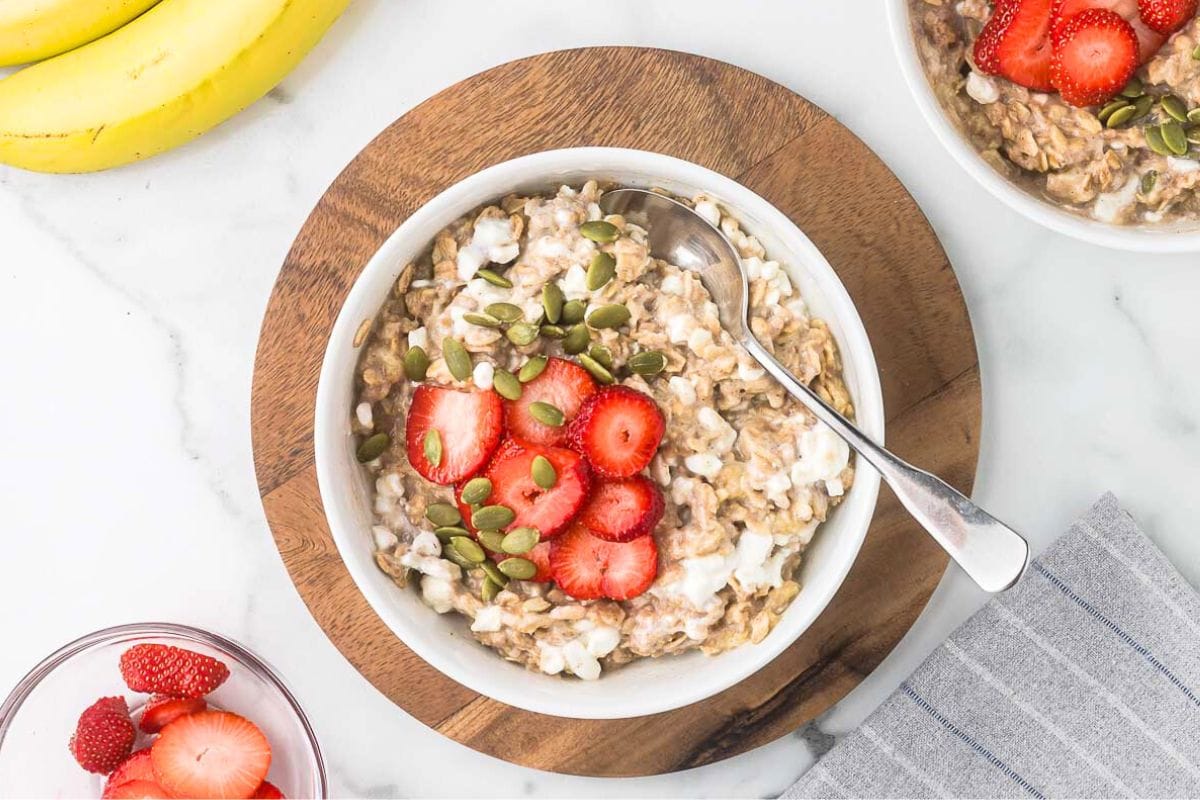 cottage cheese oatmeal in a bowl with sliced strawberries